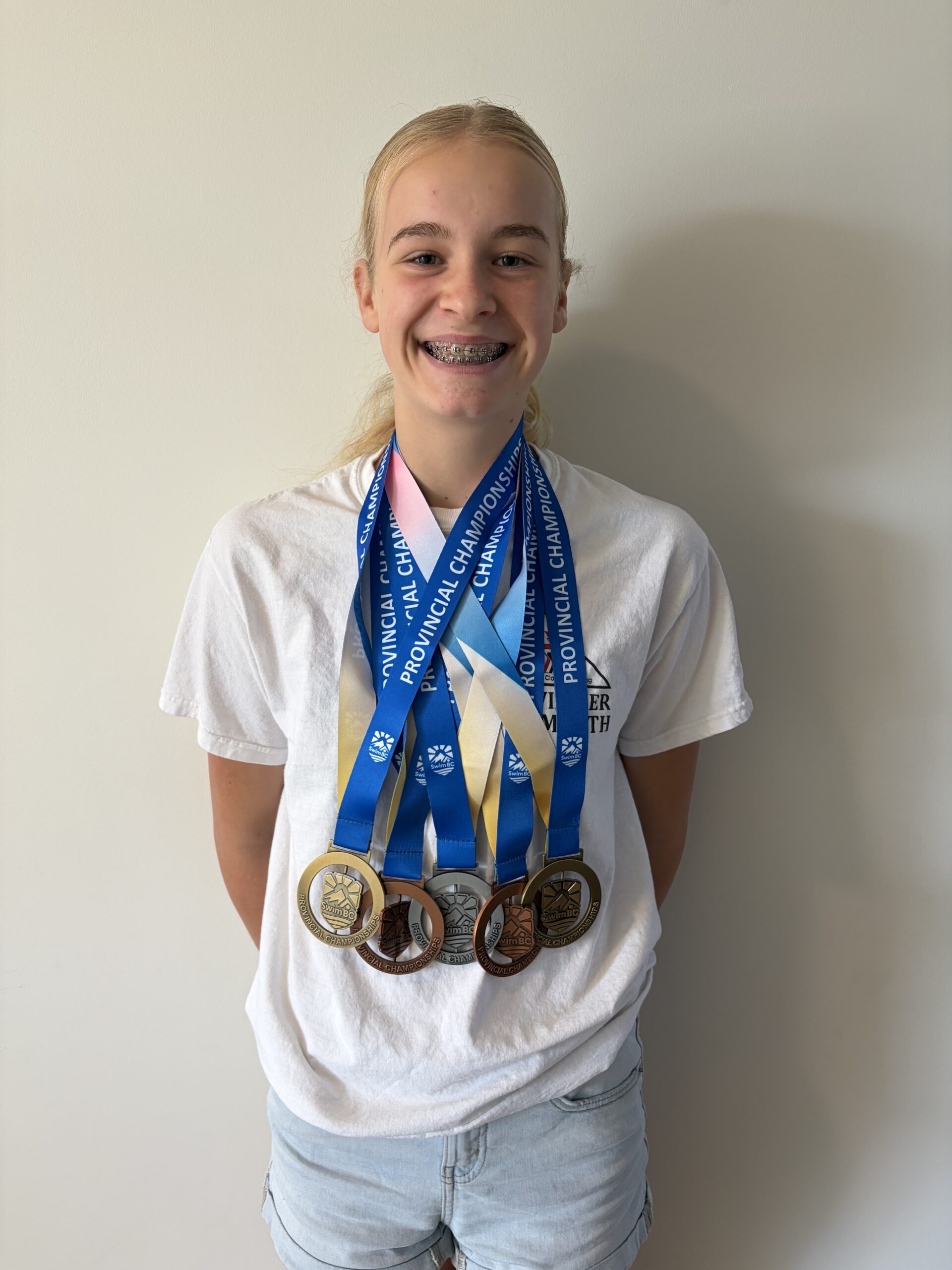Young swimmer collects medals and records at swim meet